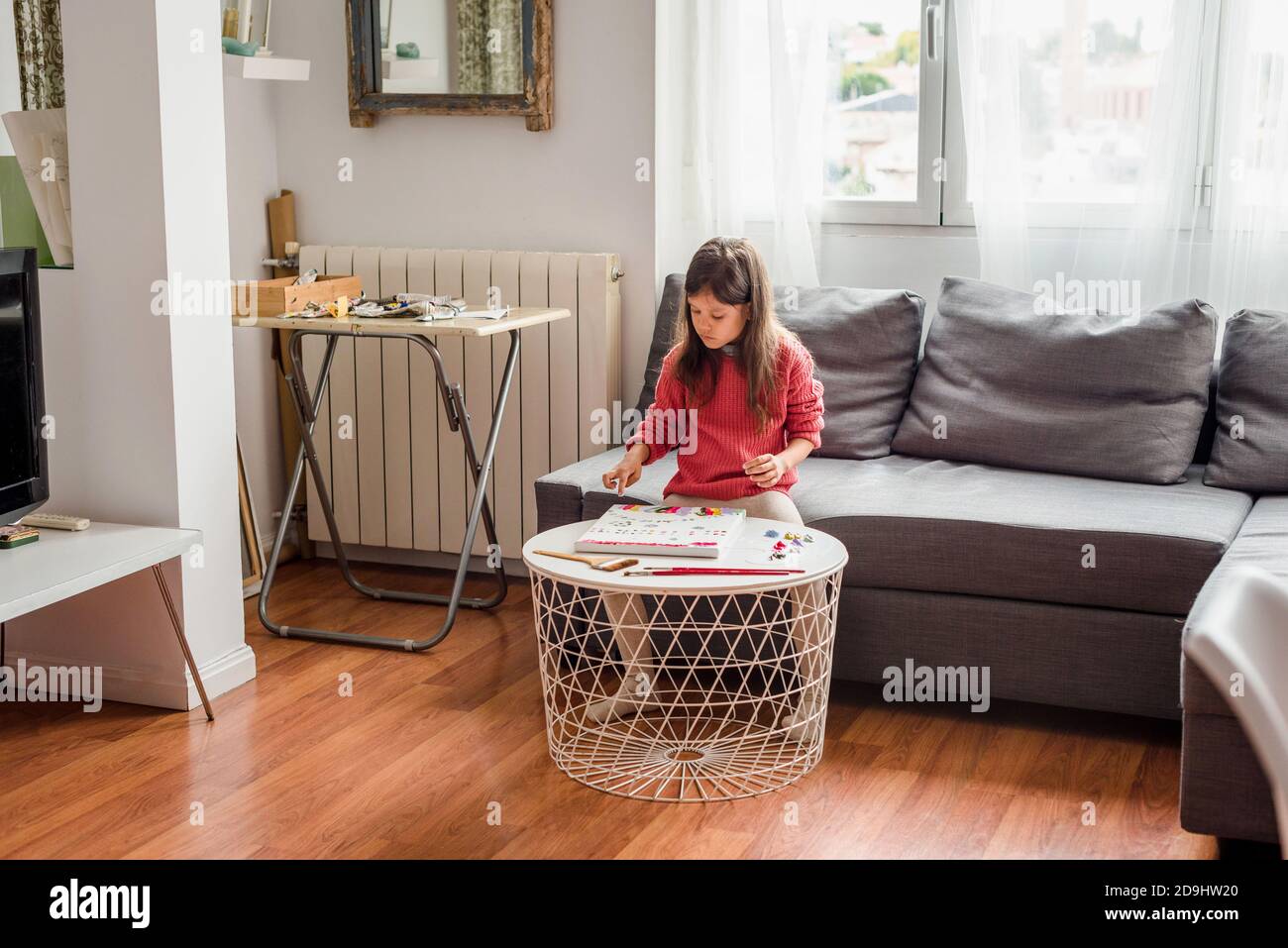 Hispanic little girl doing art class at home learning from home