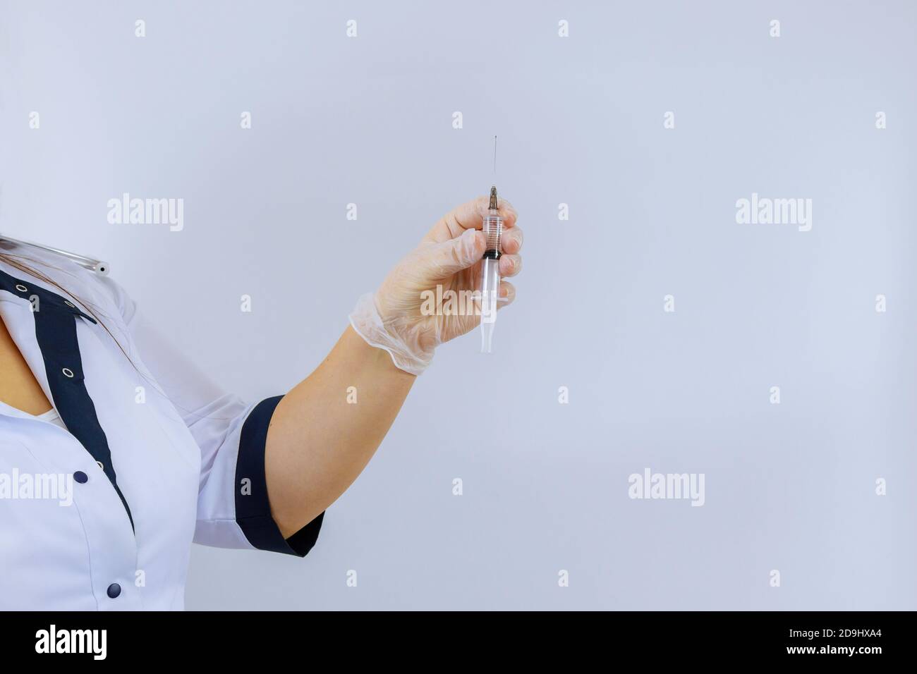 A woman doctor hand holding syringe wearing latex glove with medicine on white background Stock Photo