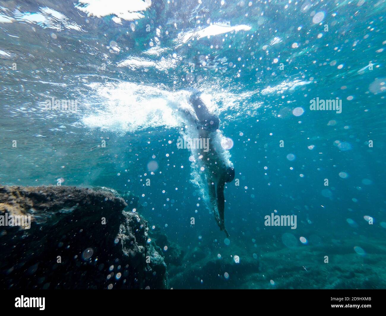 Man diving head first into the sea. View from inside the water Stock