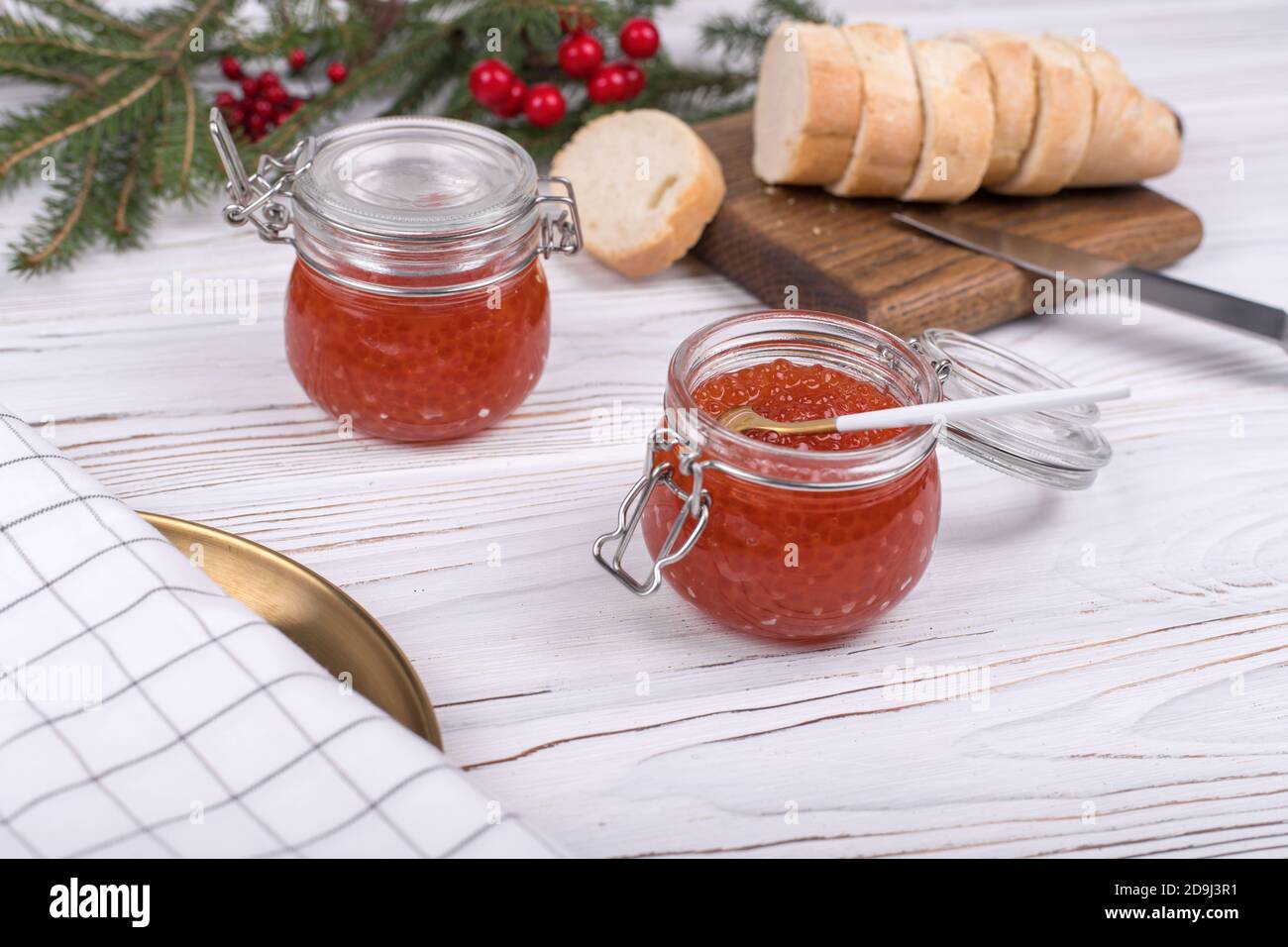 Red caviar in jar on aged white wooden background. Main dish New Year Stock Photo