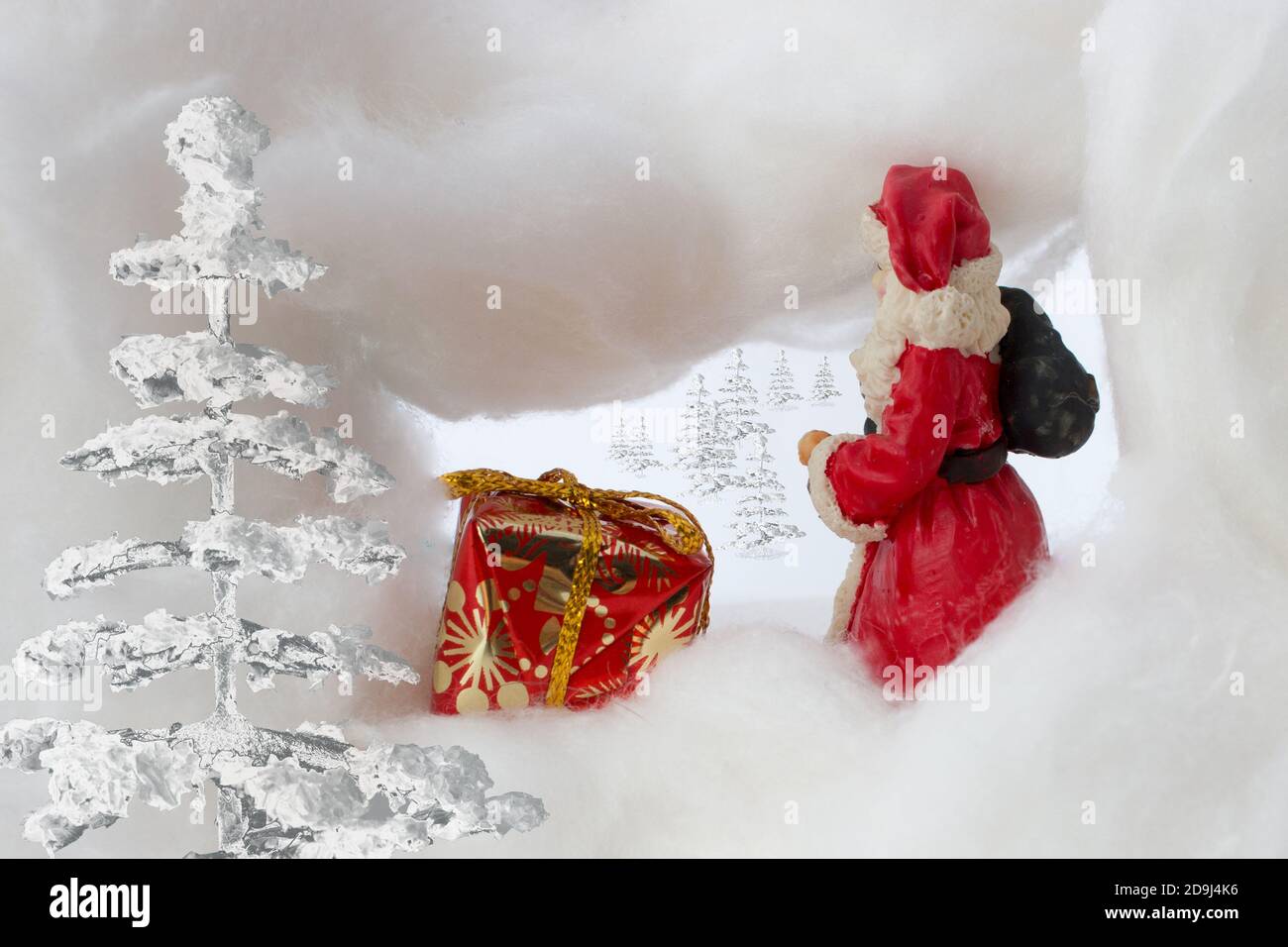 Santa claus in snowstorm with sack and gift. Trees are visible in the background. Stock Photo