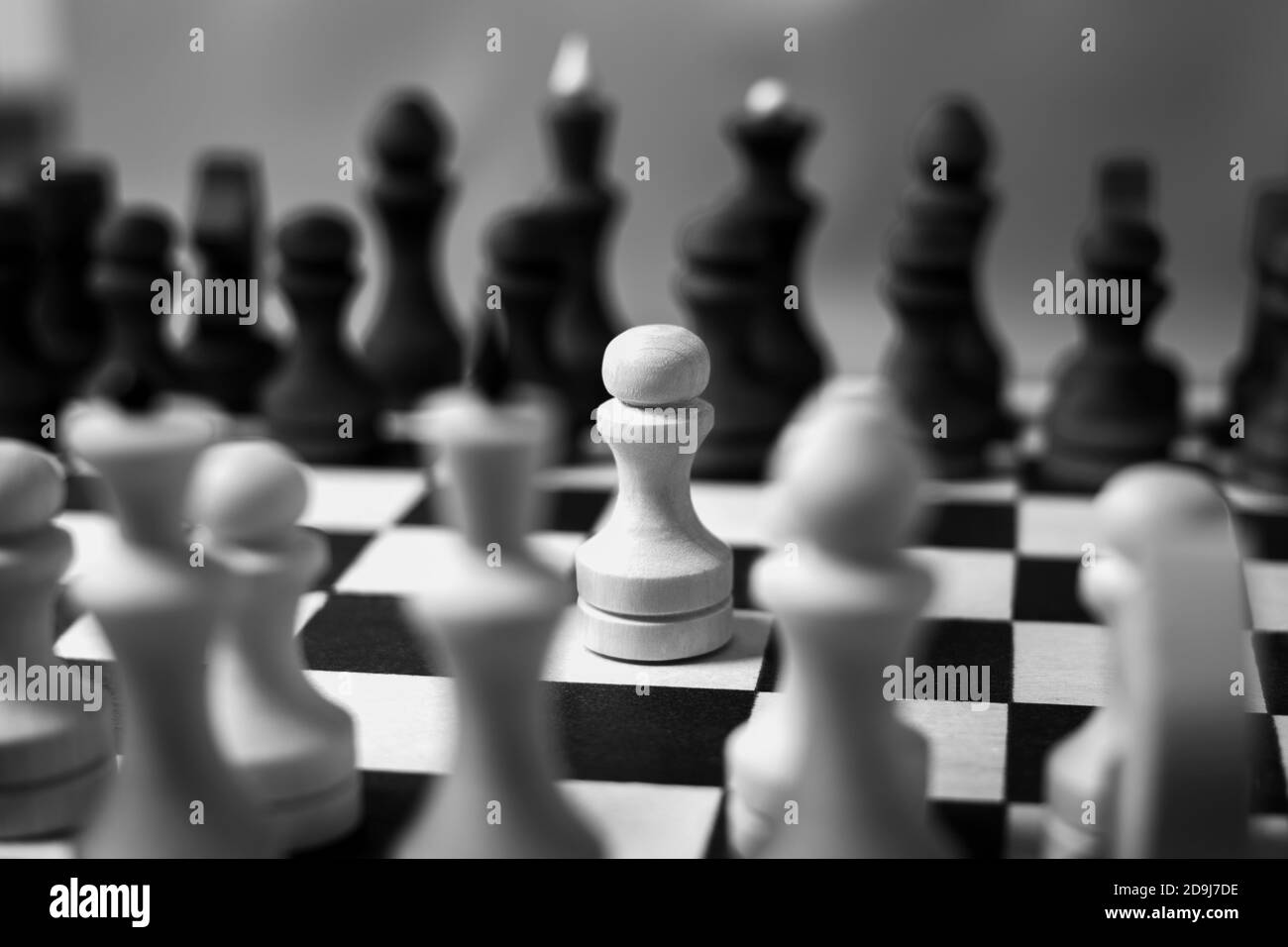 The first move in chess was made by a white pawn. Chess start, close-up, selective focus, black and white. Business concept start of business negotiations, business cooperation Stock Photo