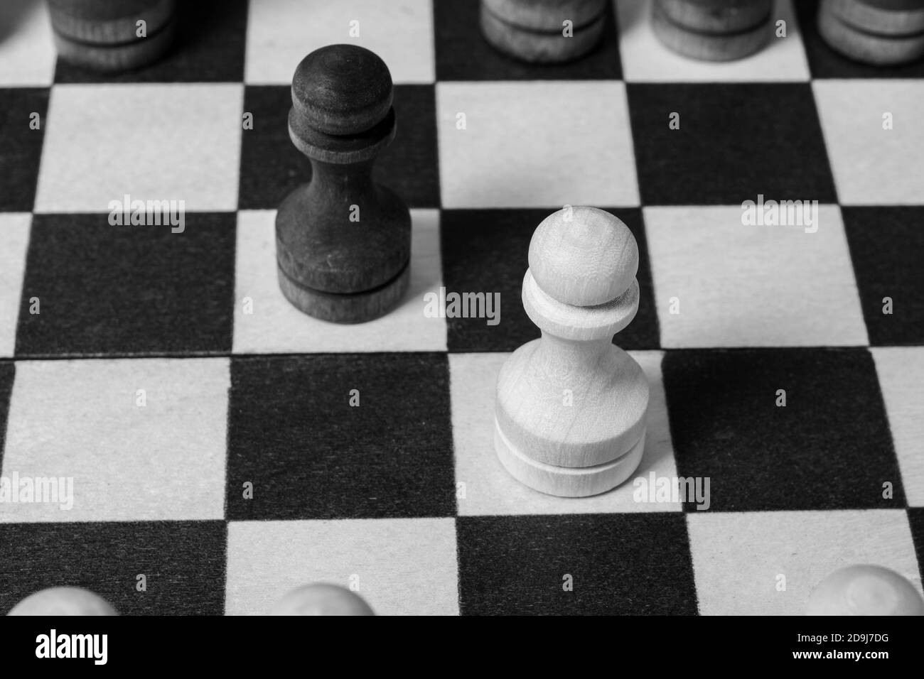 The first move in chess was made by pawns to meet each other. Chess game start, close-up, selective focus black and white. Business concept start of business negotiations, business cooperation Stock Photo