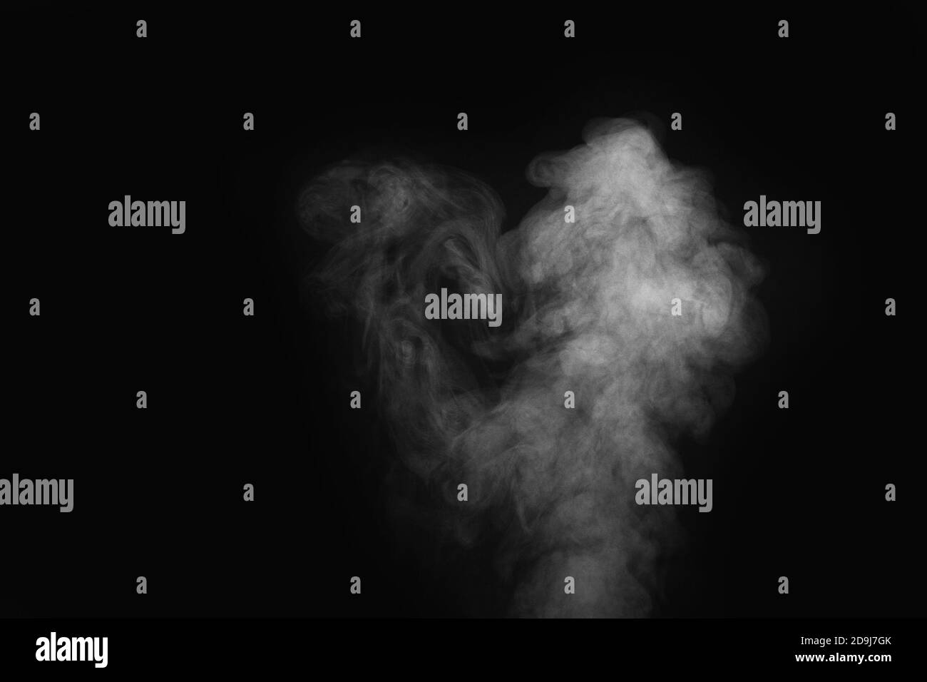 Curly smoke, steam, isolated on a black background. The smoke looks ...