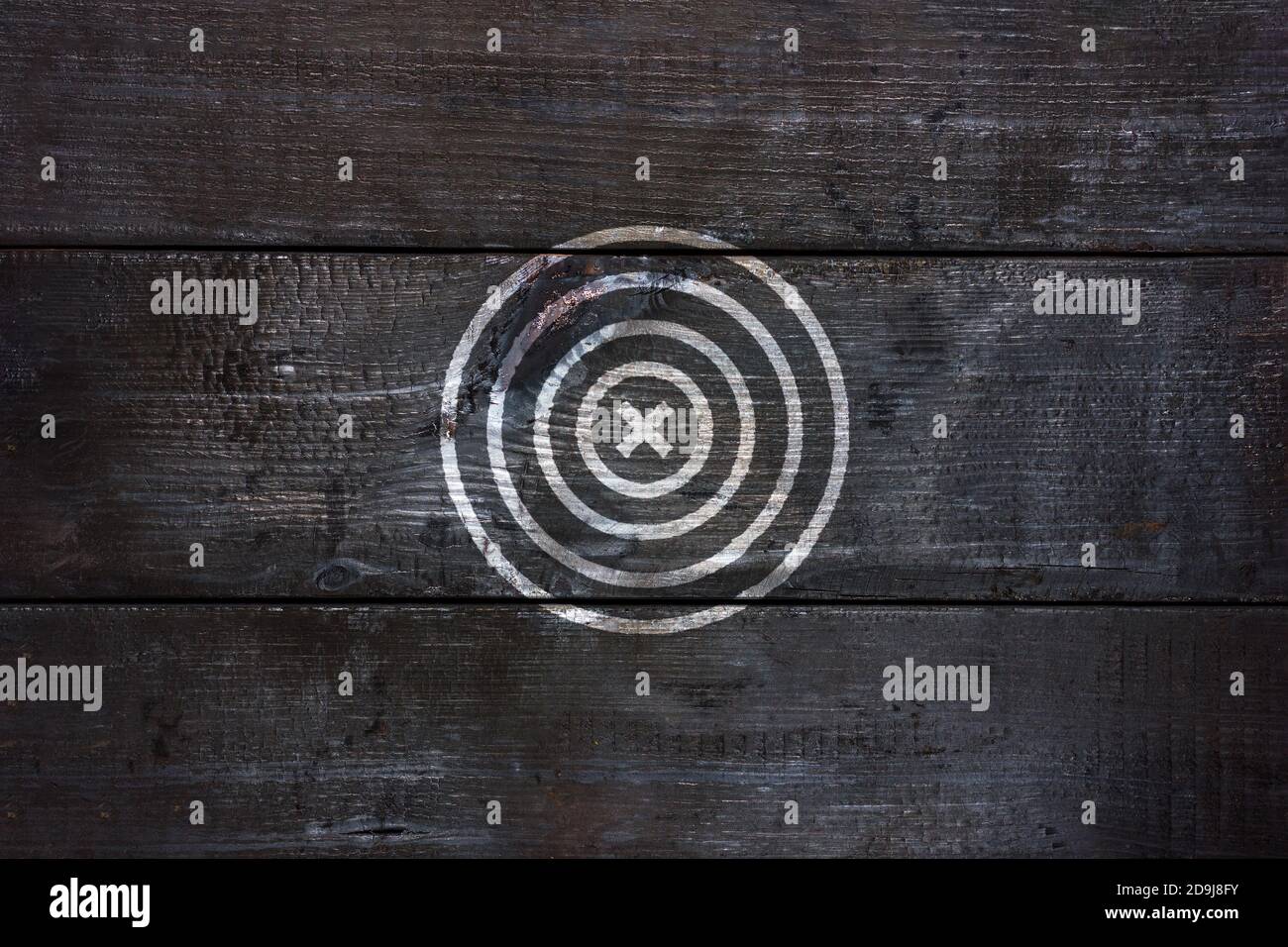 Black wooden board with painted white round target, target. Dart board