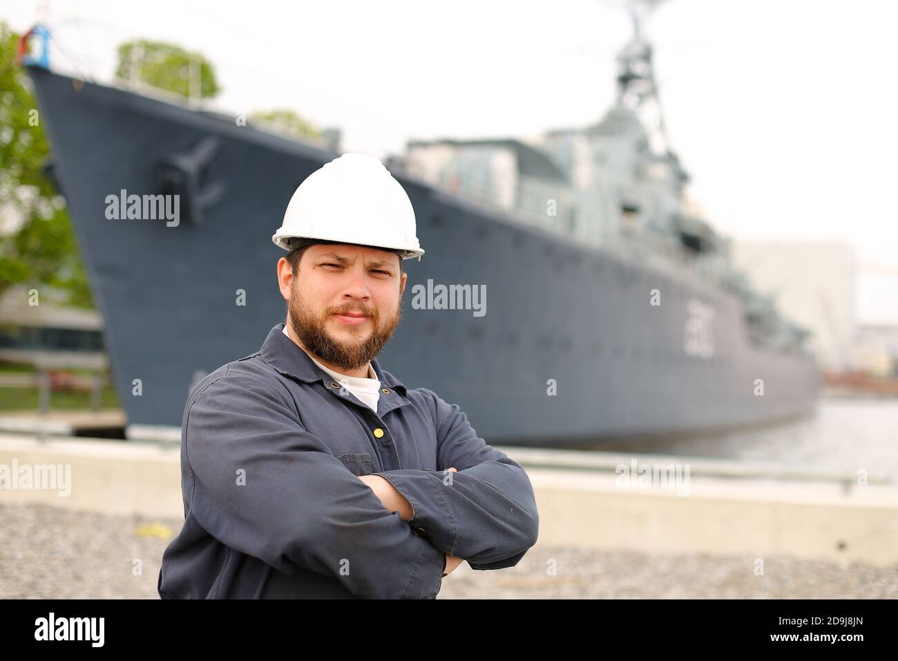 Portrait of marine chief mate standing near big vessel in background. Stock Photo
