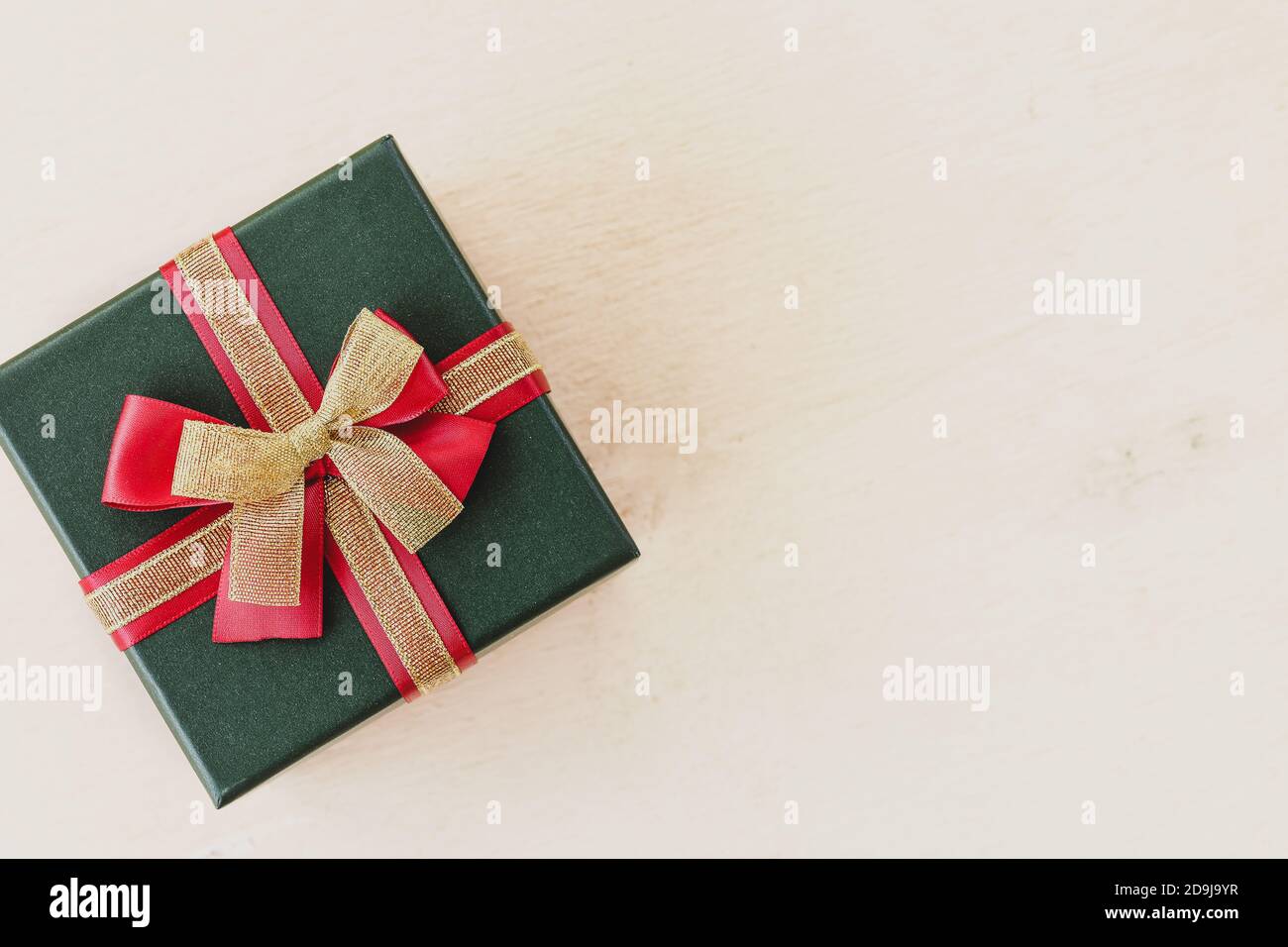 Christmas gift box with a red and golden bow on a white background ...