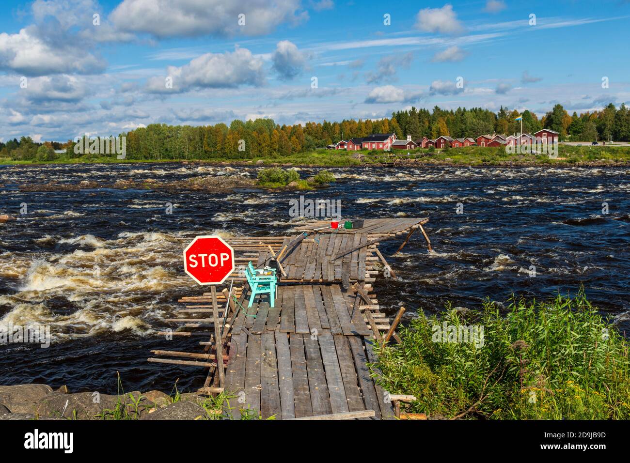 Bridge out to the rapid used for fishing with handle landing net  with a stop sign as a warning, blue sky and clouds in background, picture from kukko Stock Photo