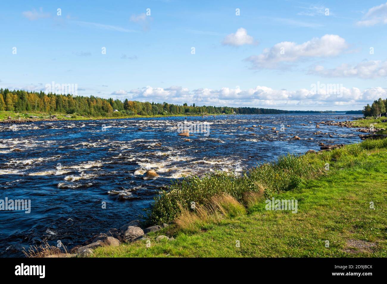 Downstream kukkola rapid in Torne river Norrbotten Sweden with a blue sky in background. Stock Photo