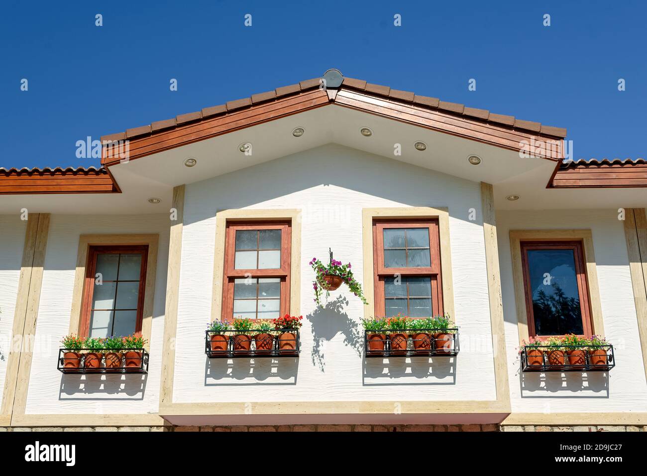 Windows with flower pots on the facade of a building in Side, Turkey