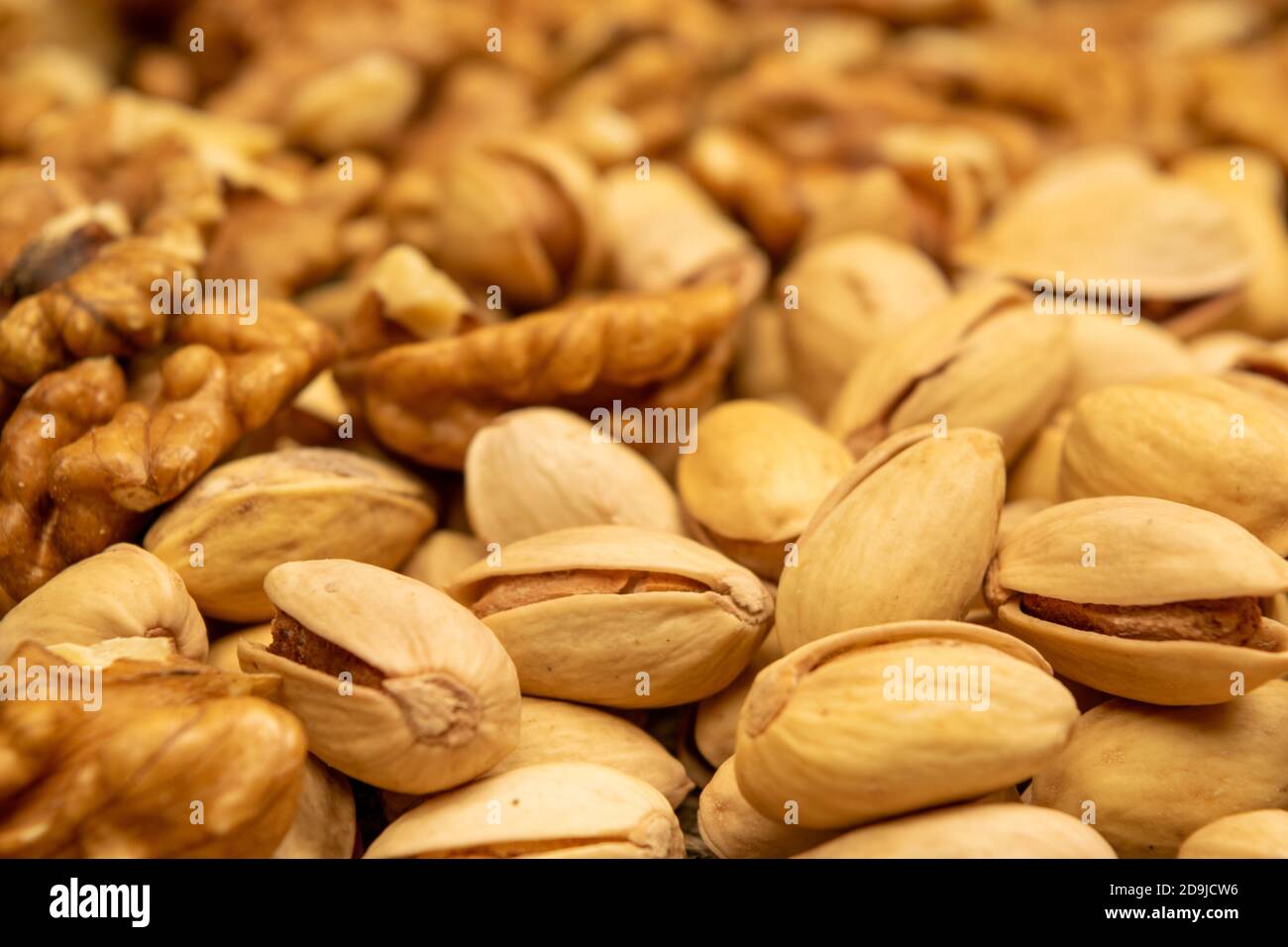Pistachios and walnuts lie on the sacking. Close up Stock Photo