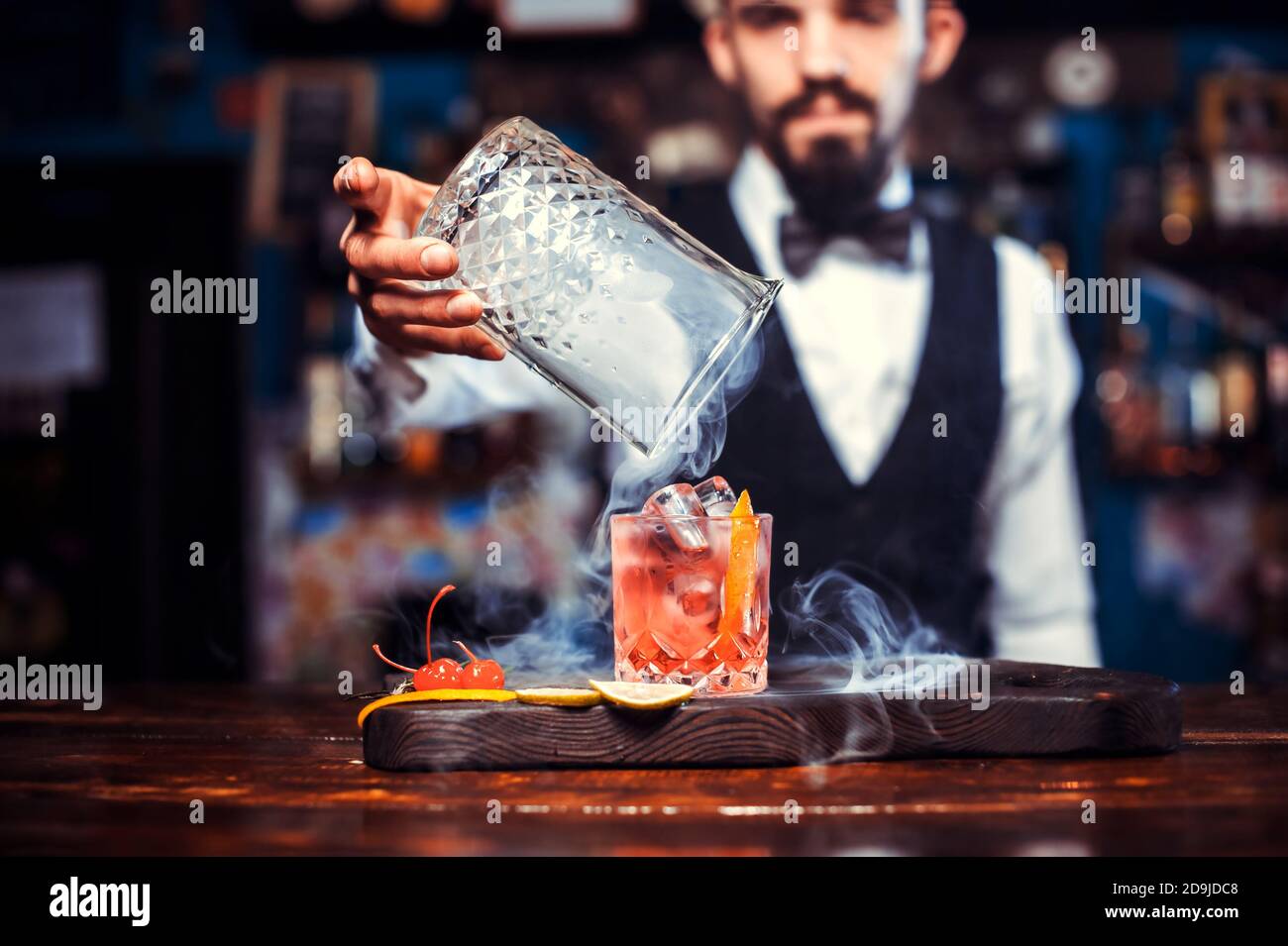 Focused bartender demonstrates the process of making a cocktail Stock Photo  - Alamy