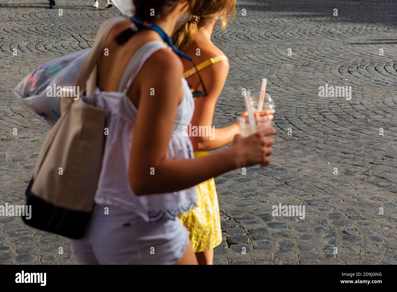 Two teenage girls carrying plastic cups with straws in Piazza Santa Maria, Trastevere, Rome, Italy. Stock Photo