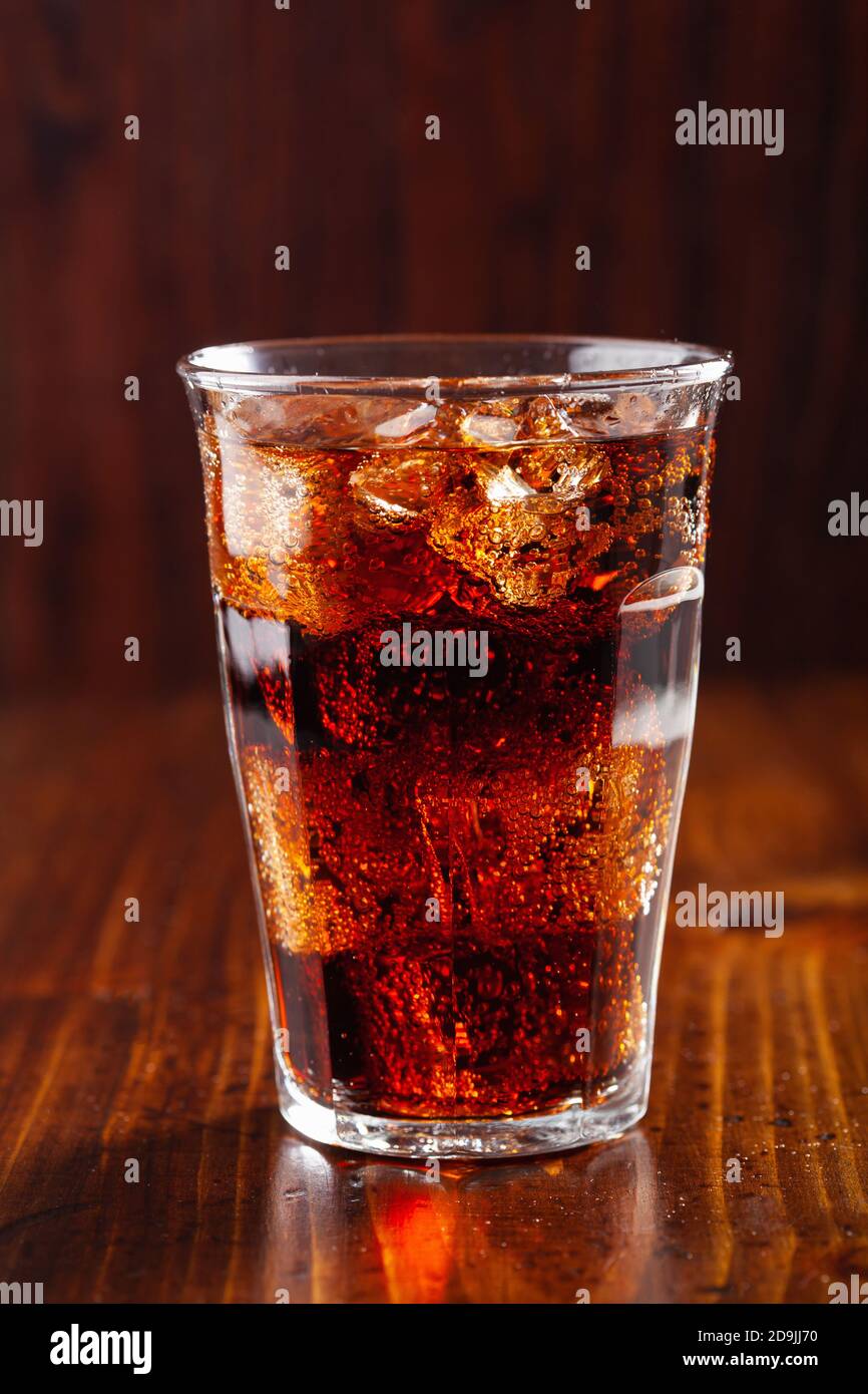 glass of cold cola soft drink with ice on wooden background Stock Photo ...