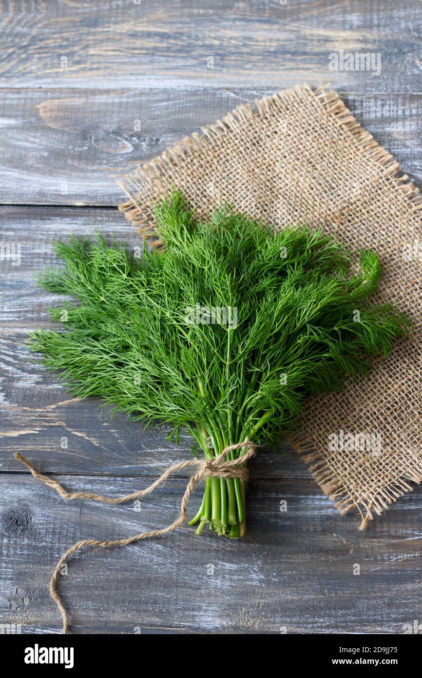 Bunch of fresh dill on a wooden surface. Rustic style, selective focus Stock Photo