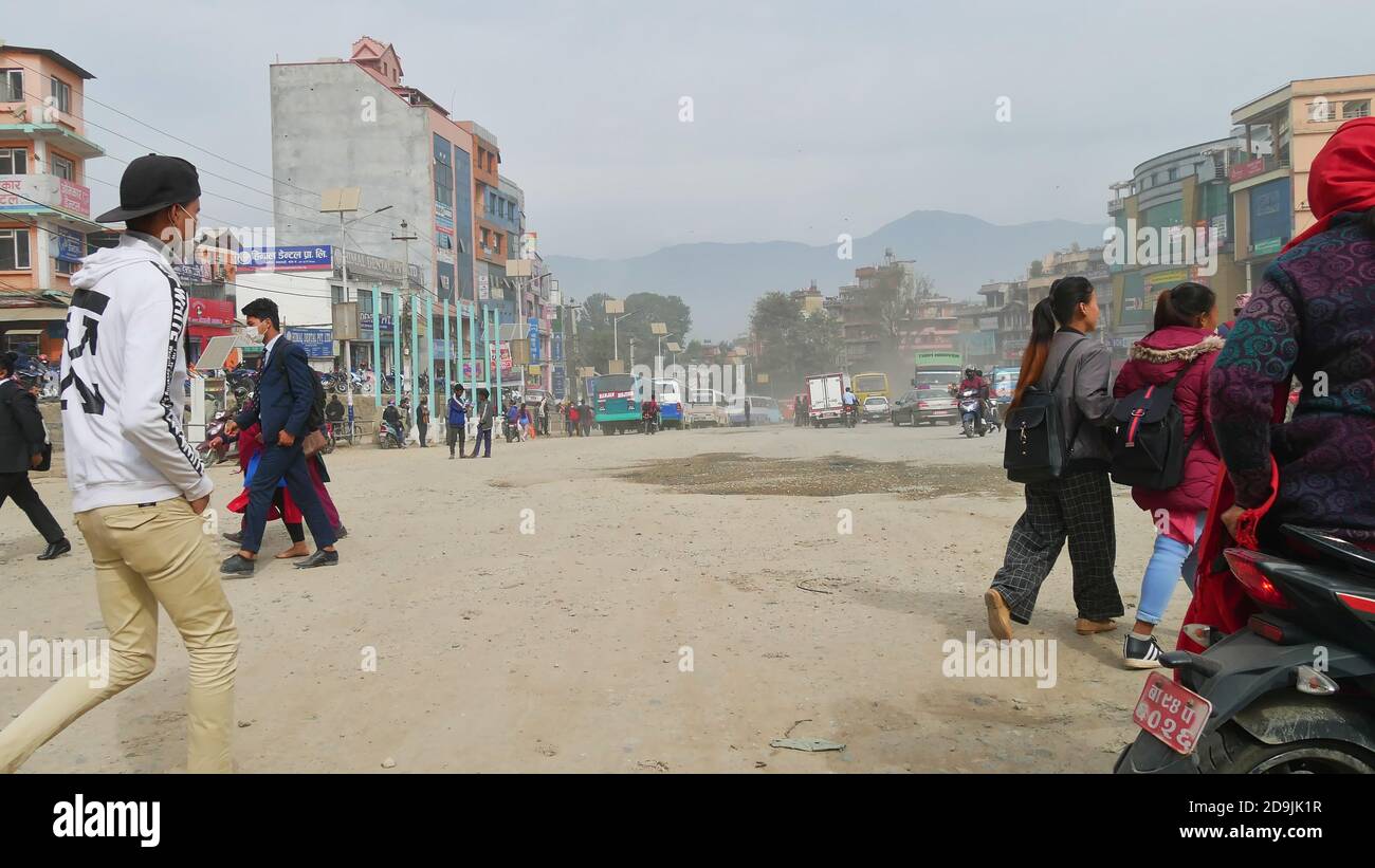 Kathmandu, Nepal - 11/29/2019: People with face masks protecting from the strong air pollution walking on a dirty street in the center of Kathmandu. Stock Photo