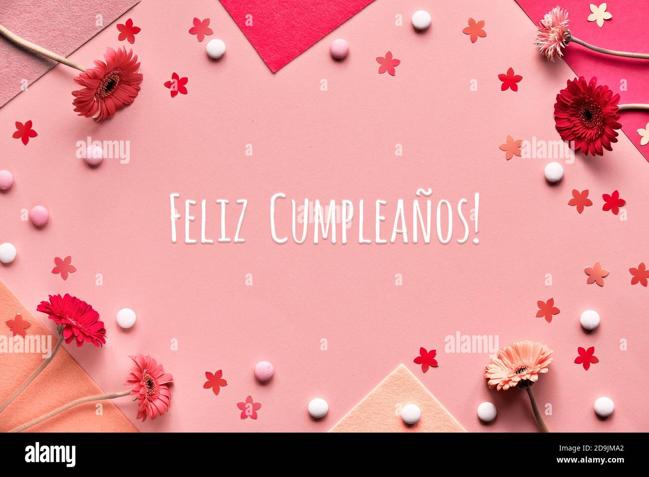 Feliz Cumpleanos means Happy Birthday in Spanish language. Flat lay,  gerbera flowers on pink paper Stock Photo - Alamy