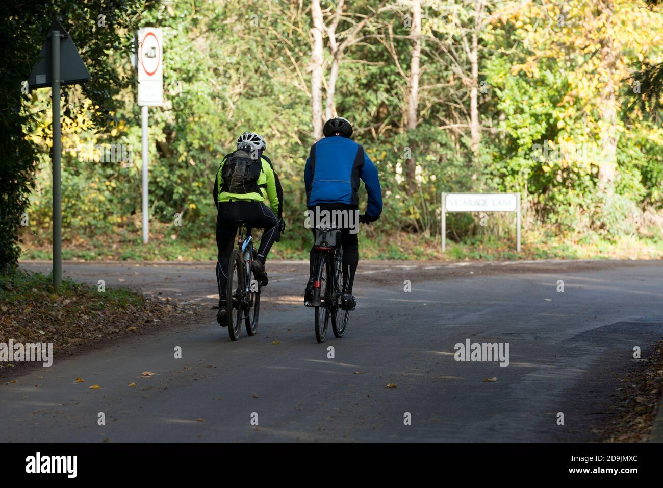 Two cyclists on a country road, Sherbourne, Warwickshire, England, UK Stock Photo