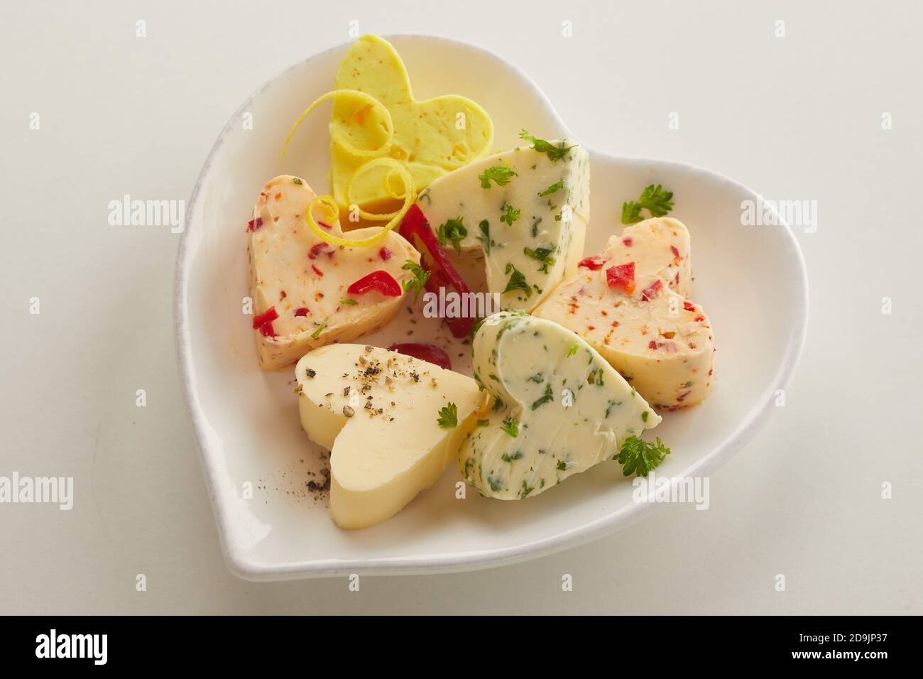 Assorted flavors of heart shaped butter patties served in a matching