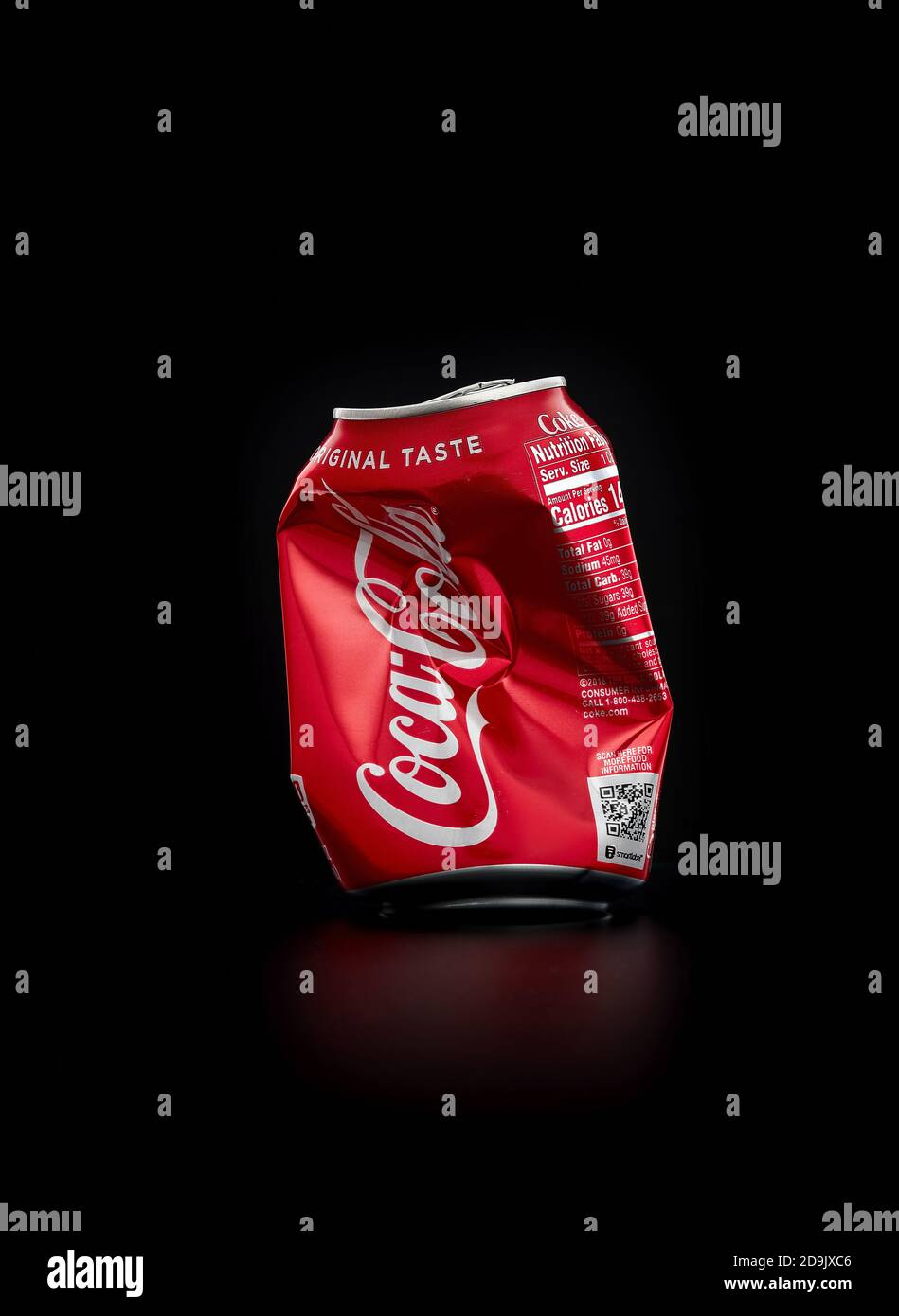 Crumpled Coca Cola can on black background. Coca Cola drinks are