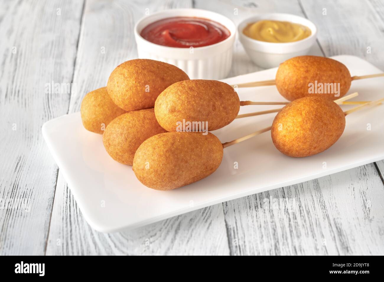 Corn dogs with dip sauces on white serving plate Stock Photo Alamy