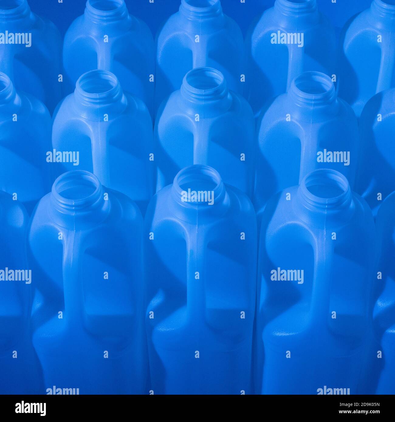 Nampak 2-litre poly HDPE milk bottles lit by coloured gels. Abstract packaging, plastic bottles, UK food packaging, supermarket milk, abstract plastic. Stock Photo