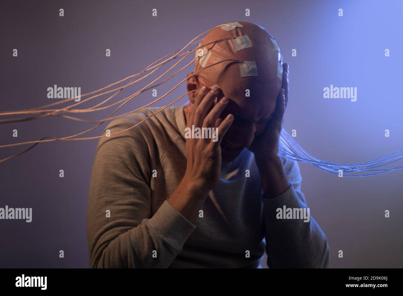 Person with implants in head experiences stress and horror. New technologies, augmented brain, neuro interface and virtuality. Stock Photo