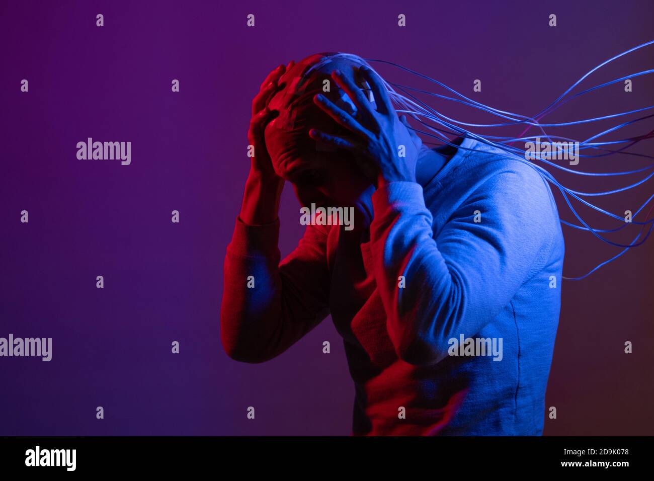 Man with electrodes in his head screams in horror, a polygraph lie detector test, memory Erasure. Stock Photo