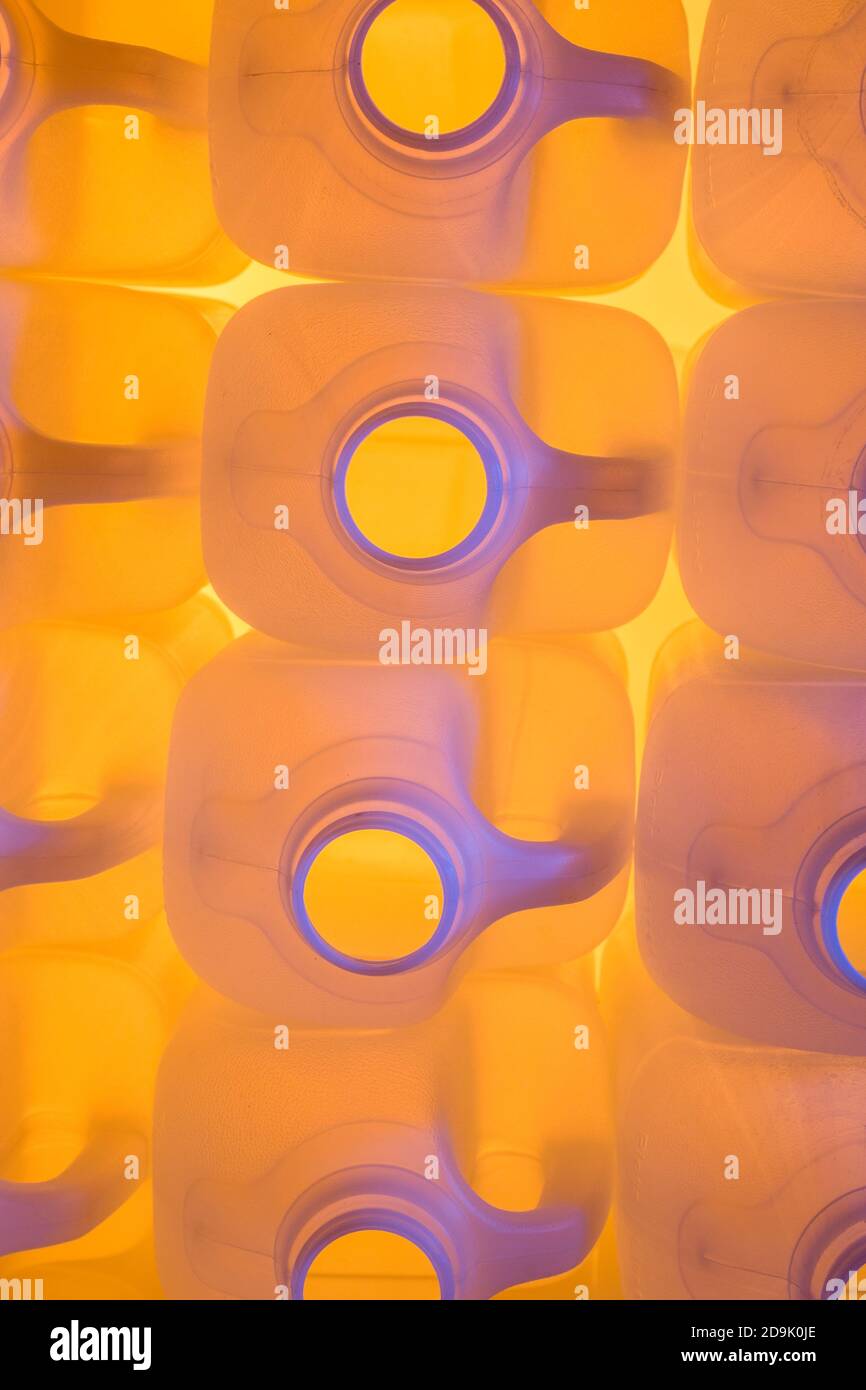 Nampak 2-litre poly HDPE milk bottles lit by coloured gels. Abstract packaging, plastic bottles, UK food packaging, supermarket milk, abstract plastic. Stock Photo