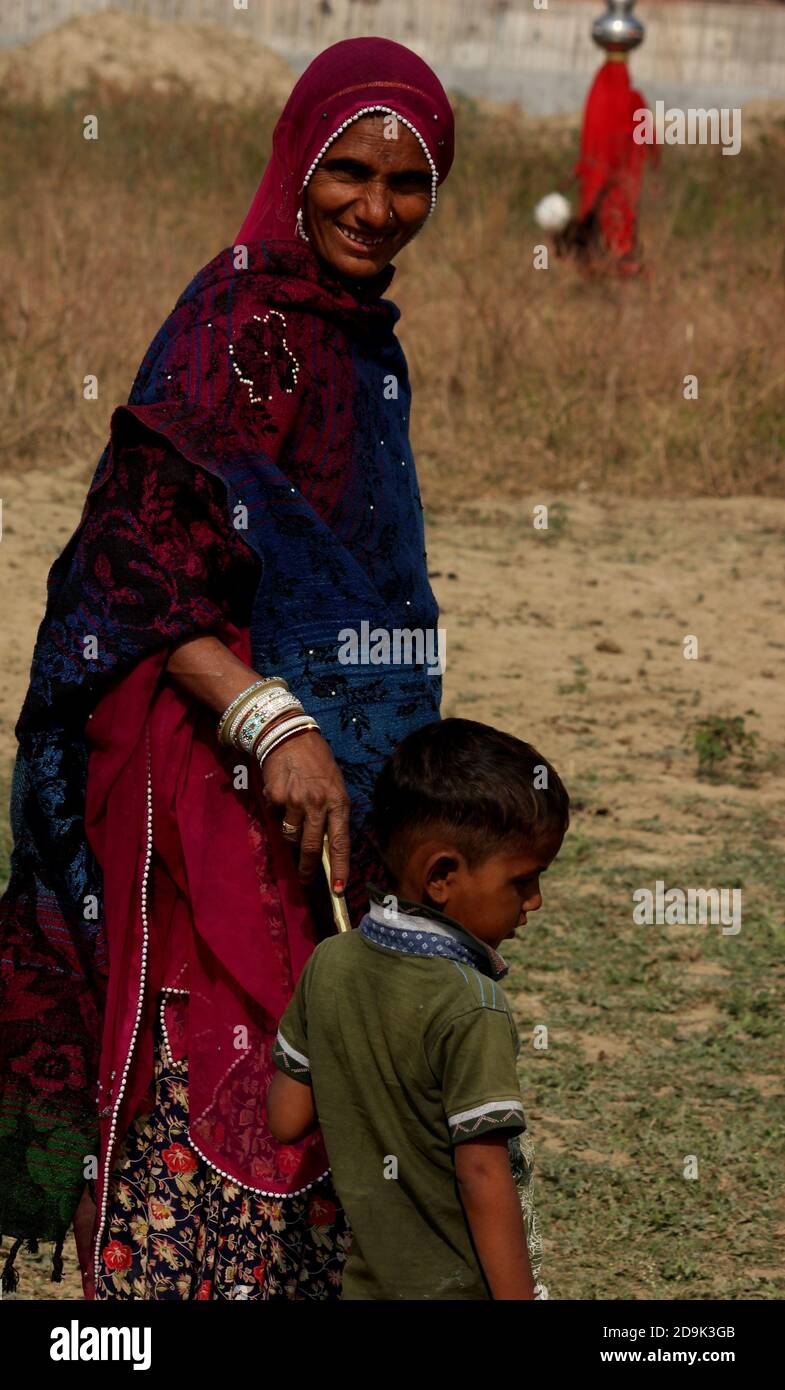 gypsy mother with the children enjoying work & her nomad life.They travells with whole family & having no home.she is indian banjara woman with grace. Stock Photo