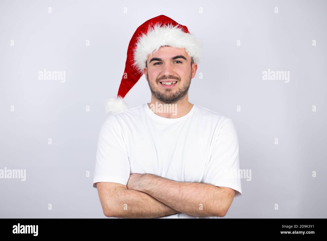 Young handsome man wearing a Santa hat over white background with a ...