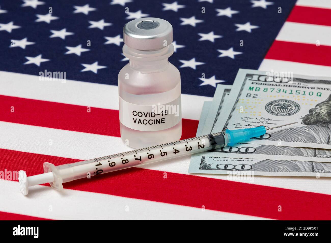 vial with Covid-19 vaccine, syringe, needle and 100 dollar bills on United States of America flag. Concept of medical research, coronavirus pandemic Stock Photo