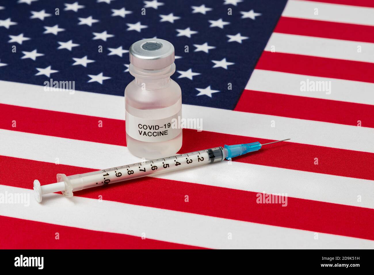 vial with Covid-19 vaccine, syringe and needle on United States of America flag. Concept of medical research and treatment, coronavirus pandemic Stock Photo