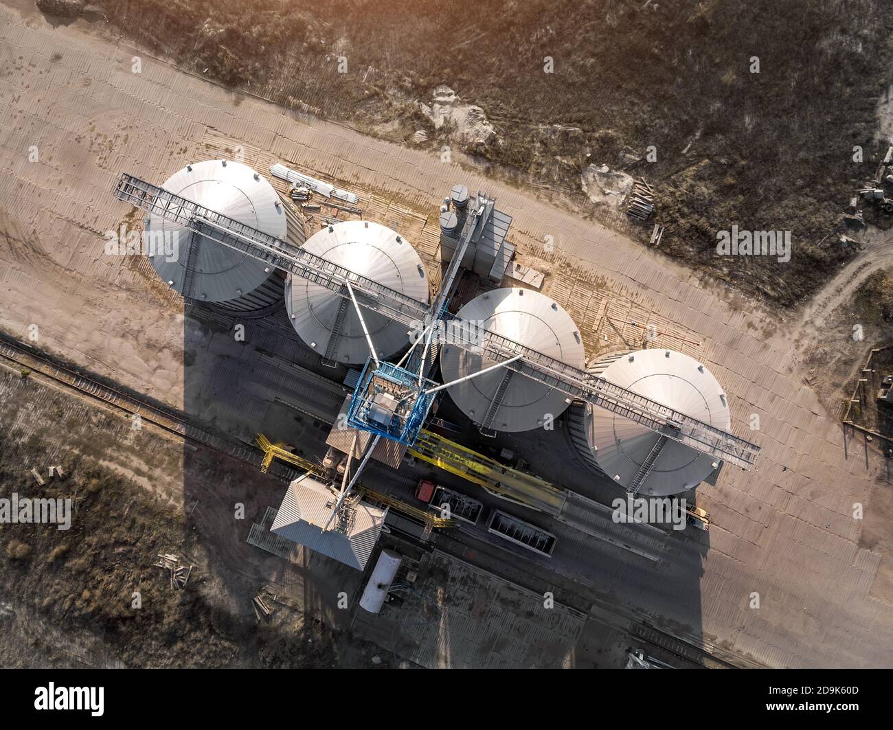 Top down view modern steel agricultural grain granary silos cereal storage warehouse loading cargo grain carrier at sunset. Agribuisness farmland Stock Photo
