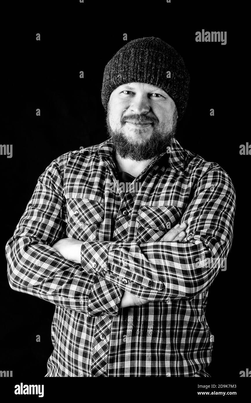 Solid bearded man in a wool cap portrait on black background Stock Photo