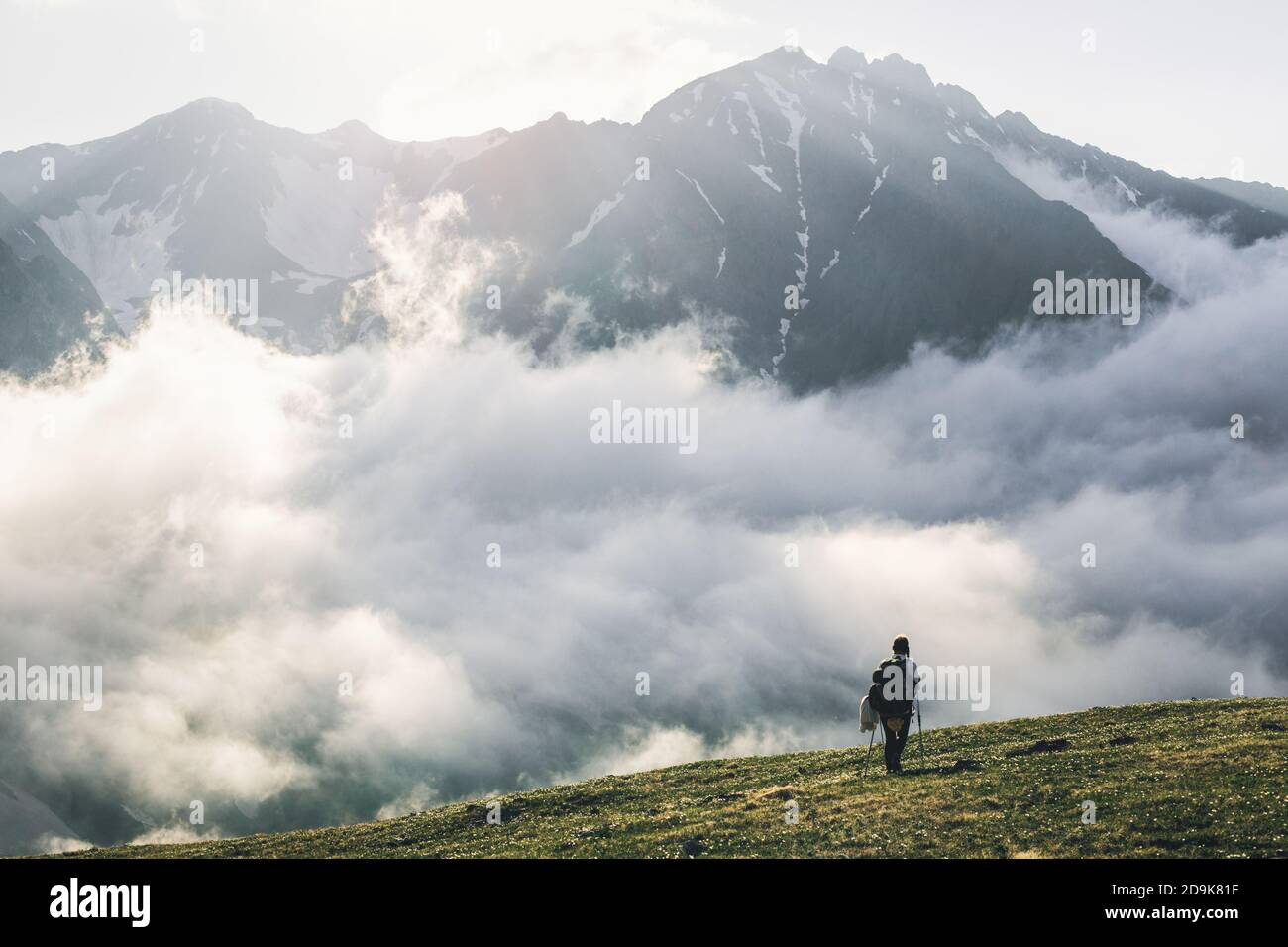 Woman hiking at sunset mountains with heavy backpack Travel Lifestyle wanderlust adventure concept summer vacations outdoor alone into the wild Stock Photo