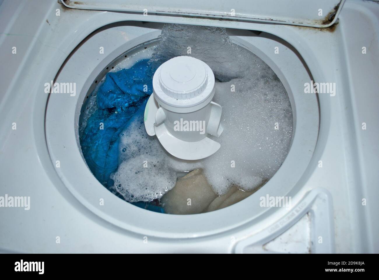 load of dirty towels in a washing machine filling with water Stock