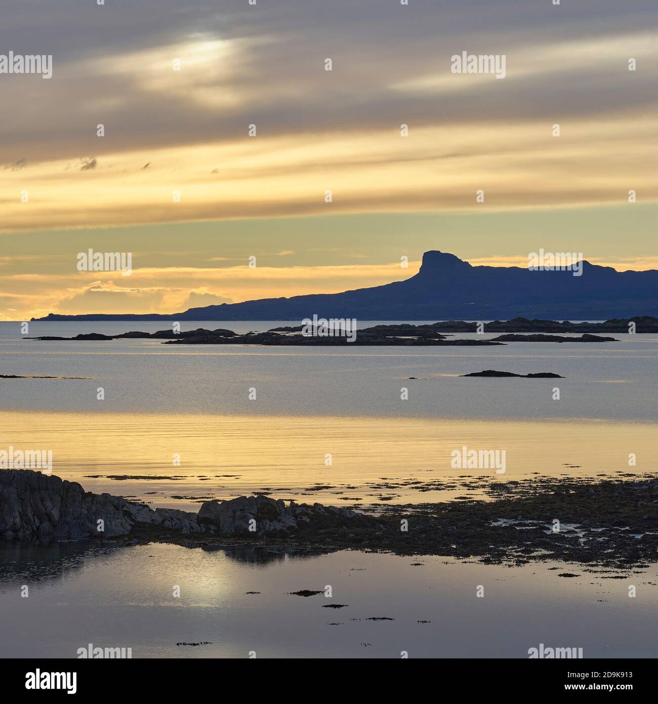 Sunset over the Isle of Eigg in the Small Isles, viewed from the Rhu Peninsula, Arisaig, Lochaber, Highland, Scotland. Stock Photo