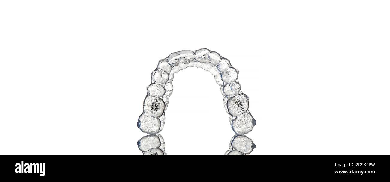 Invisible orthodontics cosmetic brackets on white background, tooth aligners, plastic braces. A way to have a beautiful smile and white teeth. Stock Photo
