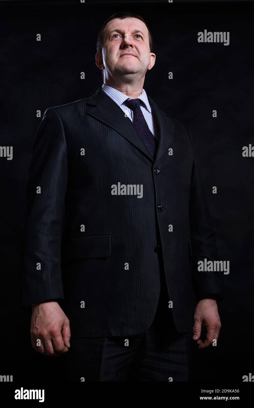 Solid Man Middle aged solid man dressed in suit studio portrait on black ...