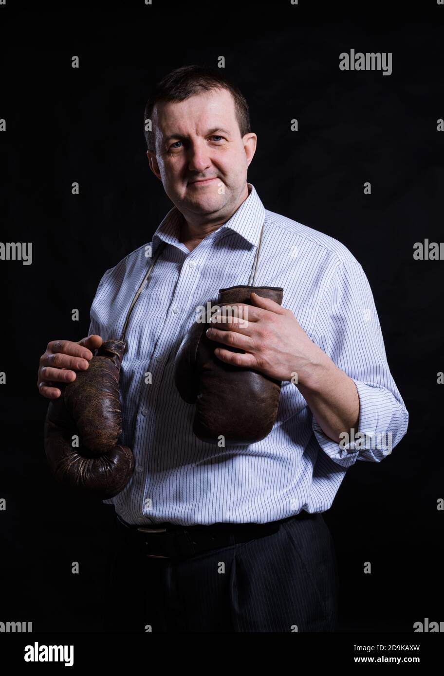 Solid Man Middle aged solid man with old boxing gloves dressed in shirt studio ...