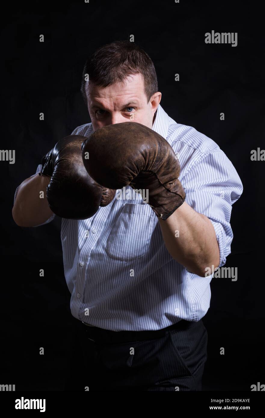 Solid Man Middle aged solid man with old boxing gloves dressed in shirt studio ...