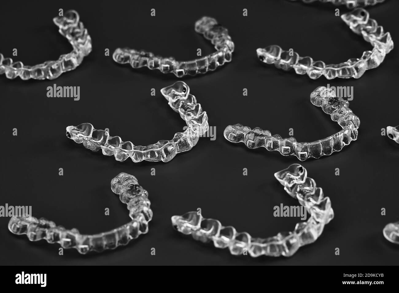 Invisible orthodontics cosmetic brackets on black background, tooth