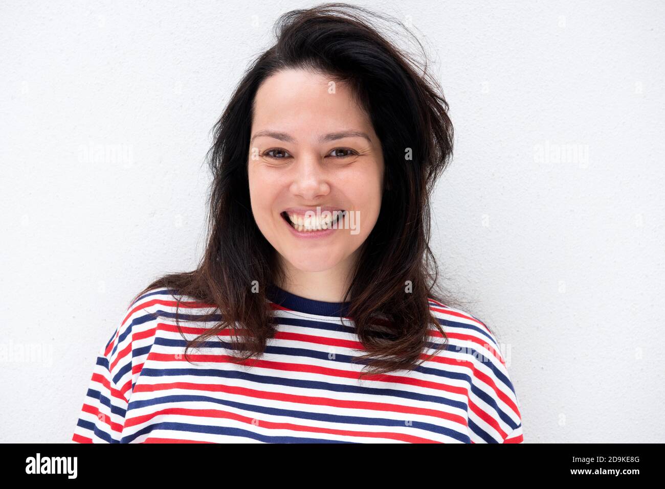 Close up portrait smiling young woman against isolated white background ...