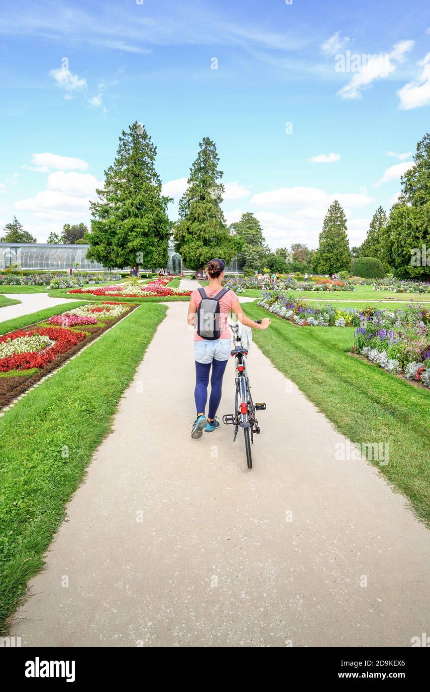 Girl with bike in flower garden of Lednice chateau in South Moravia – UNESCO (Czech Republic) Stock Photo