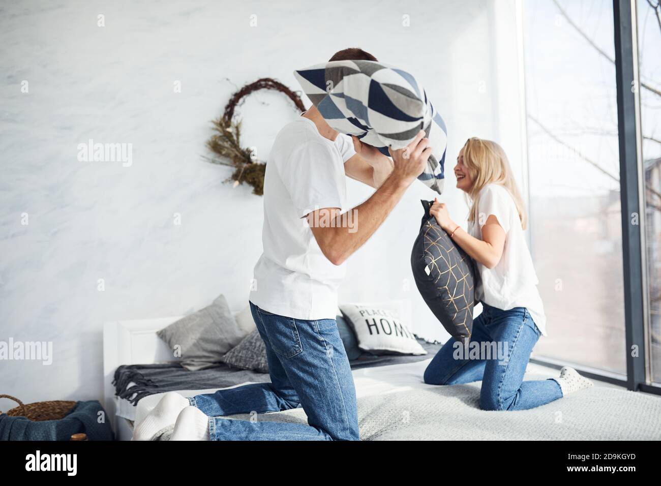 Young lovely couple together at home playing pillow fight in bedroom Stock Photo
