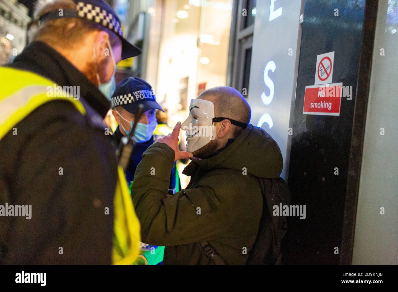 A man in Guy Fawkes mask is detained by police during the Million Mask March attended by many lockdown sceptics, London, 5 November 2020 Stock Photo