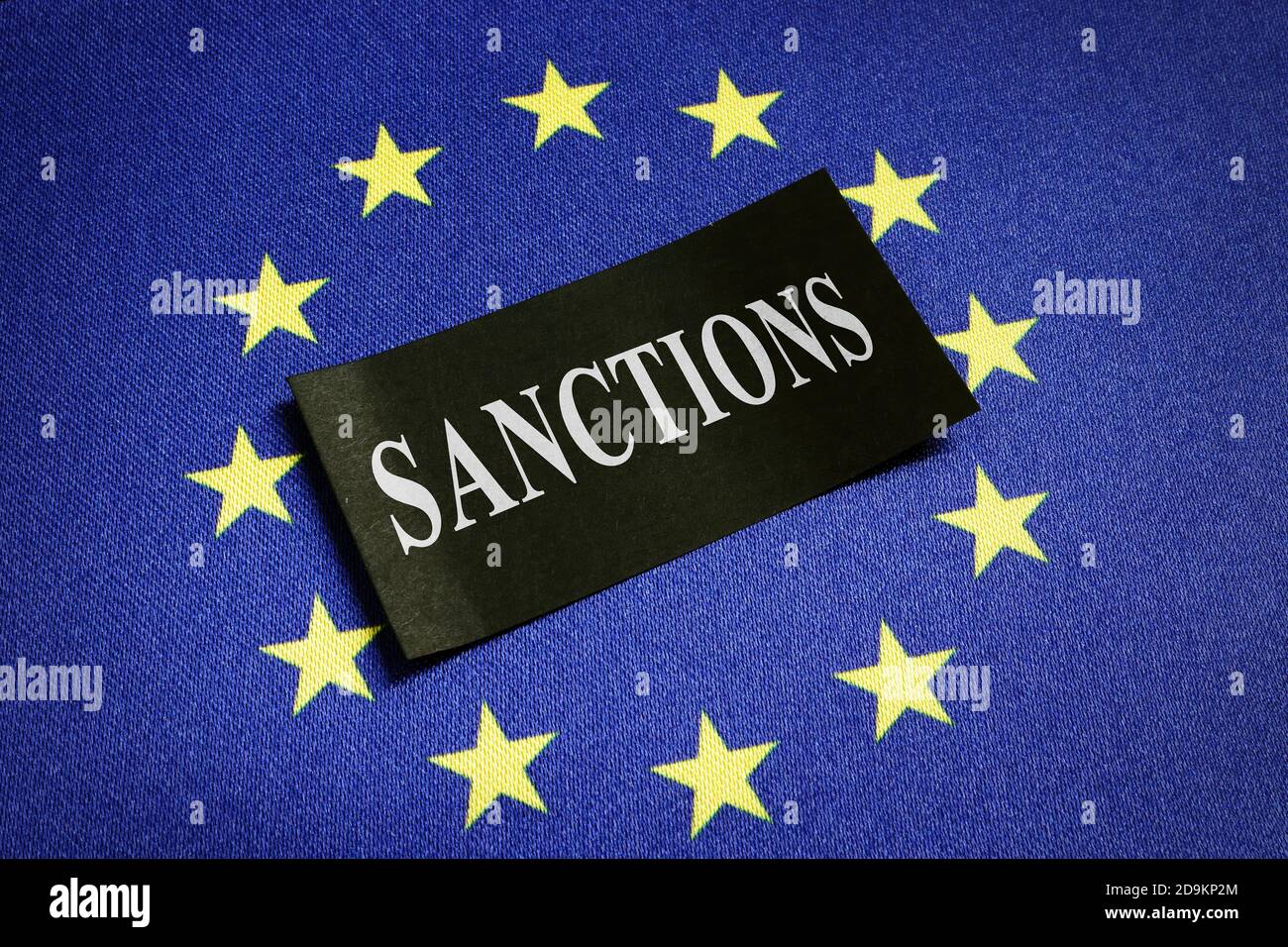 Europe Union EU flag and word sanctions on it. Stock Photo