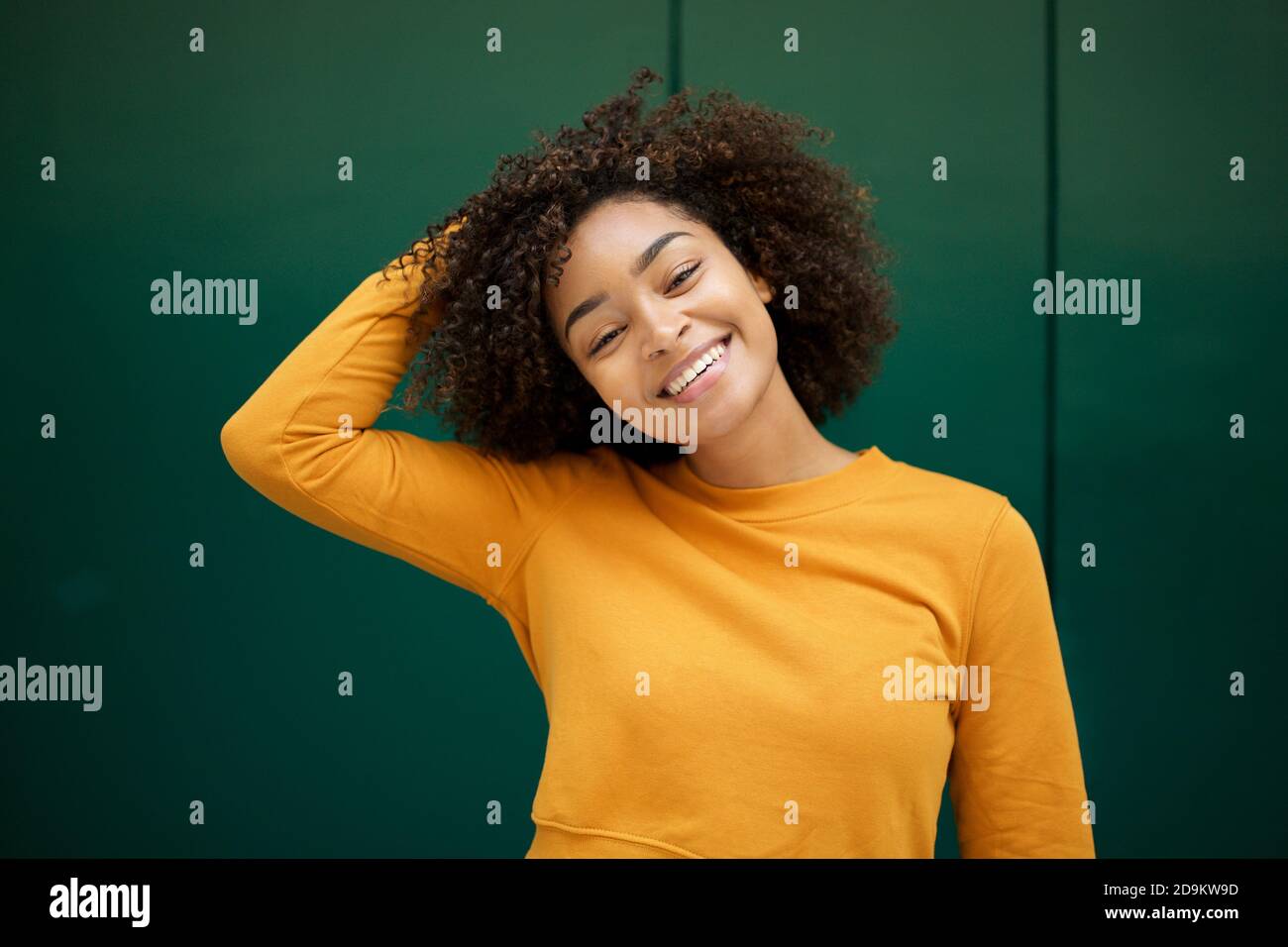 Close up portrait happy young African american woman with hand in hair ...