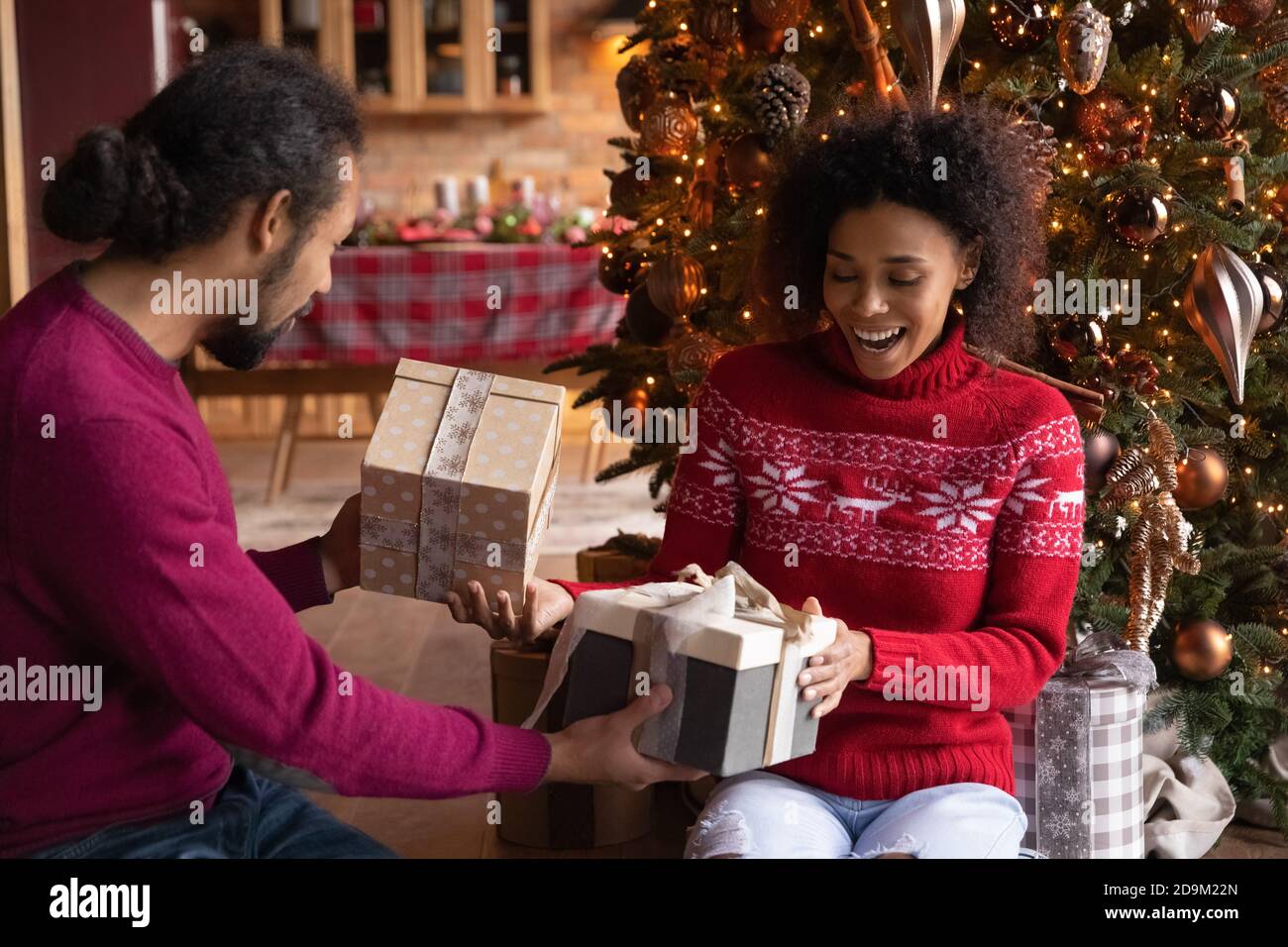 Overjoyed African American man and woman giving Christmas gifts Stock ...